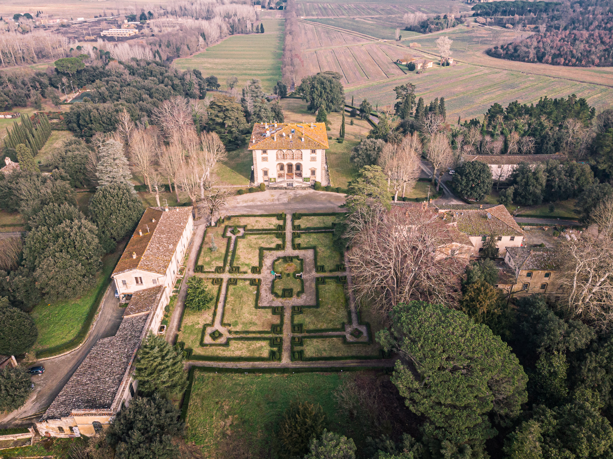 Veduta aerea di Villa Varramista e del suo giardino all’italiana, circondati da alberi, edifici storici e terreni agricoli nelle campagne di Montopoli in Val d’Arno.