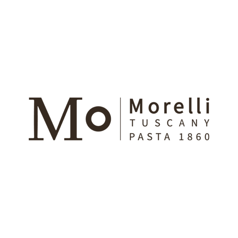 Pasta corta artigianale appena prodotta, raccolta in grandi contenitori blu all’interno del pastificio Morelli, con gli addetti al lavoro sullo sfondo.
