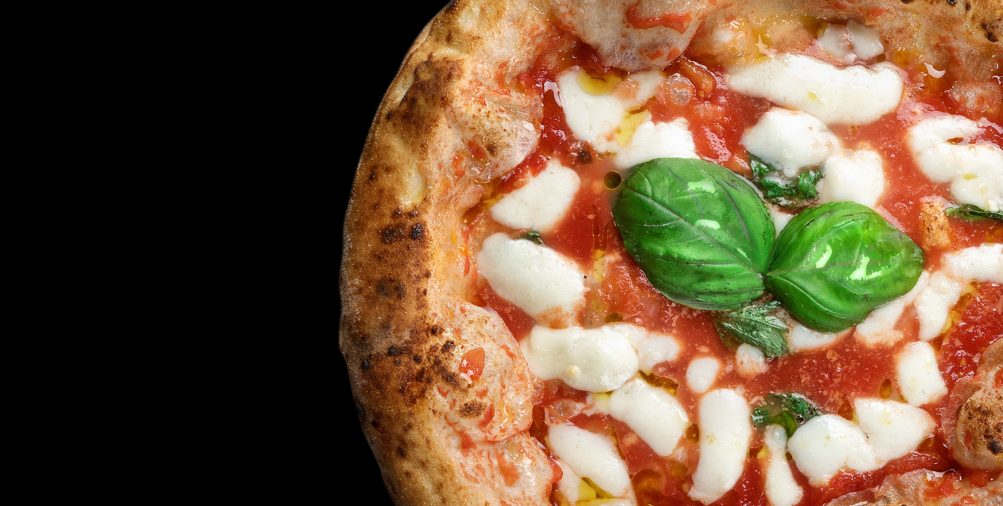 Primo piano di una pizza margherita contemporanea con pomodoro, mozzarella, basilico fresco e cornicione alto e ben cotto, su sfondo nero.