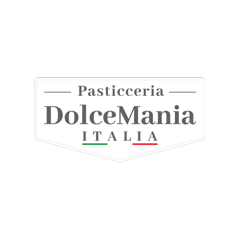 Pasticcere nel laboratorio di DolceMania Italia, circondato da panettone, biscotti, croissant e altri prodotti di pasticceria artigianale.