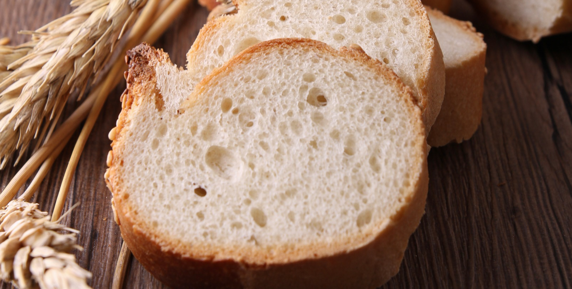 Fette di pane accanto a spighe di grano