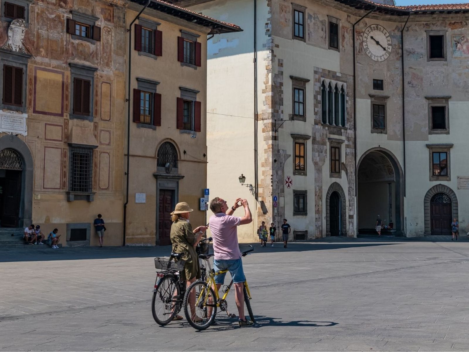 Coppia in bicicletta in Piazza dei Cavalieri a Pisa