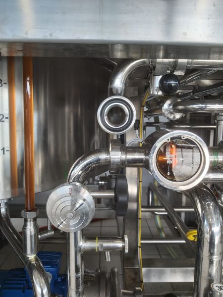 Lattine di birra artigianale OrzoBruno disposte in file, con diverse etichette e referenze del birrificio in primo piano e sullo sfondo.