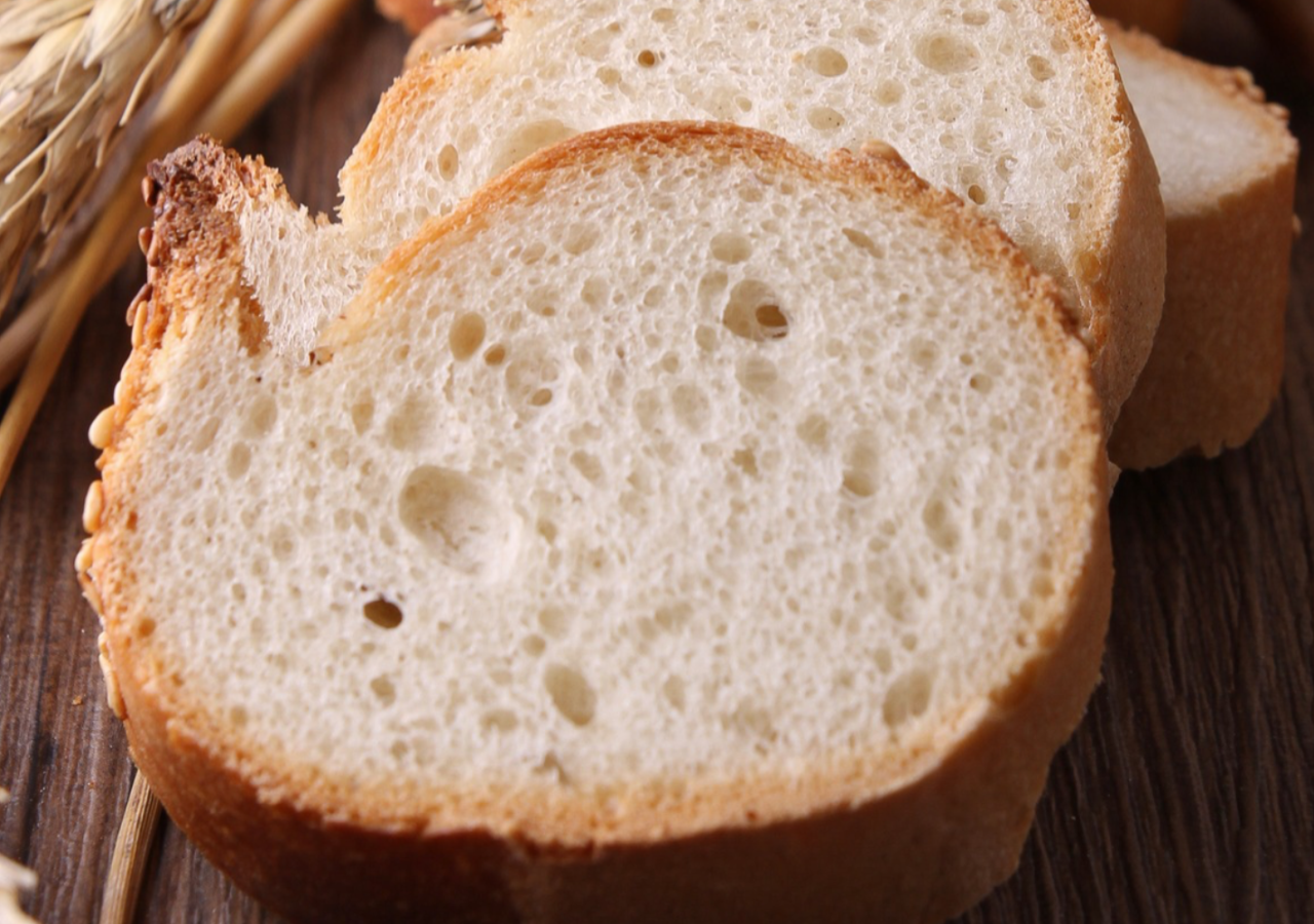 Fette di pane accanto a spighe di grano