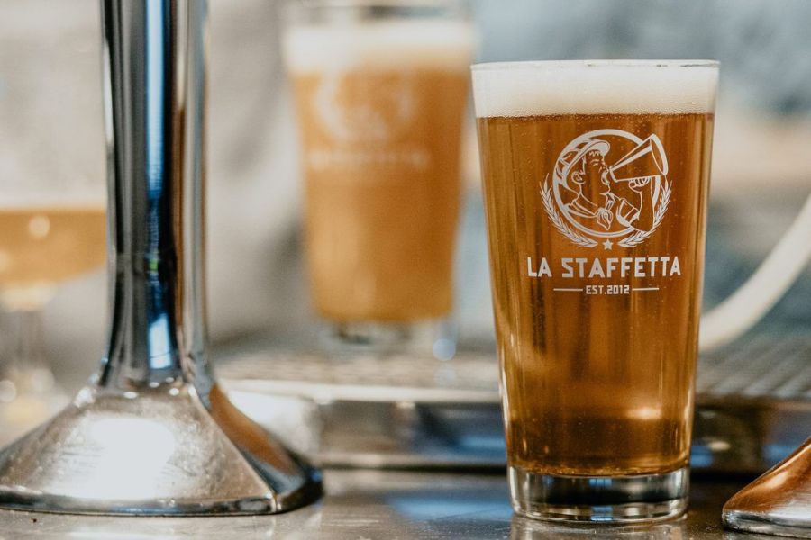 Birraio del Birrificio La Staffetta al lavoro sull’impianto di produzione, accanto ai fermentatori in acciaio.
