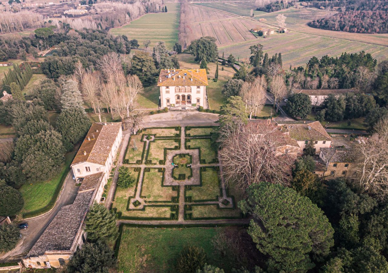 Veduta aerea di Villa Varramista e del suo giardino all’italiana, circondati da alberi, edifici storici e terreni agricoli nelle campagne di Montopoli in Val d’Arno.