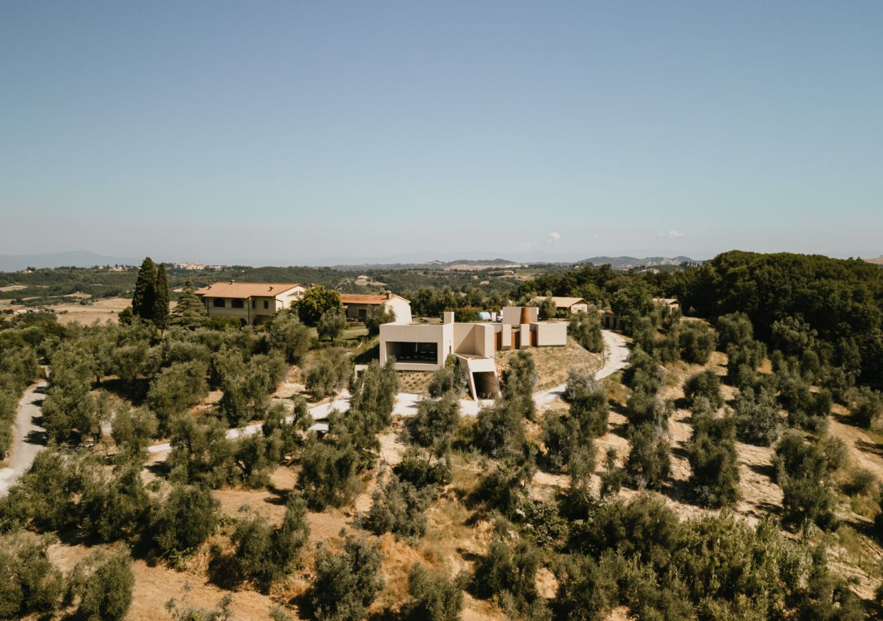Veduta aerea dell’Antica Fornace tra le colline della Valdera, con oliveti, boschi e gli edifici dell’azienda immersi nel paesaggio rurale di Peccioli.