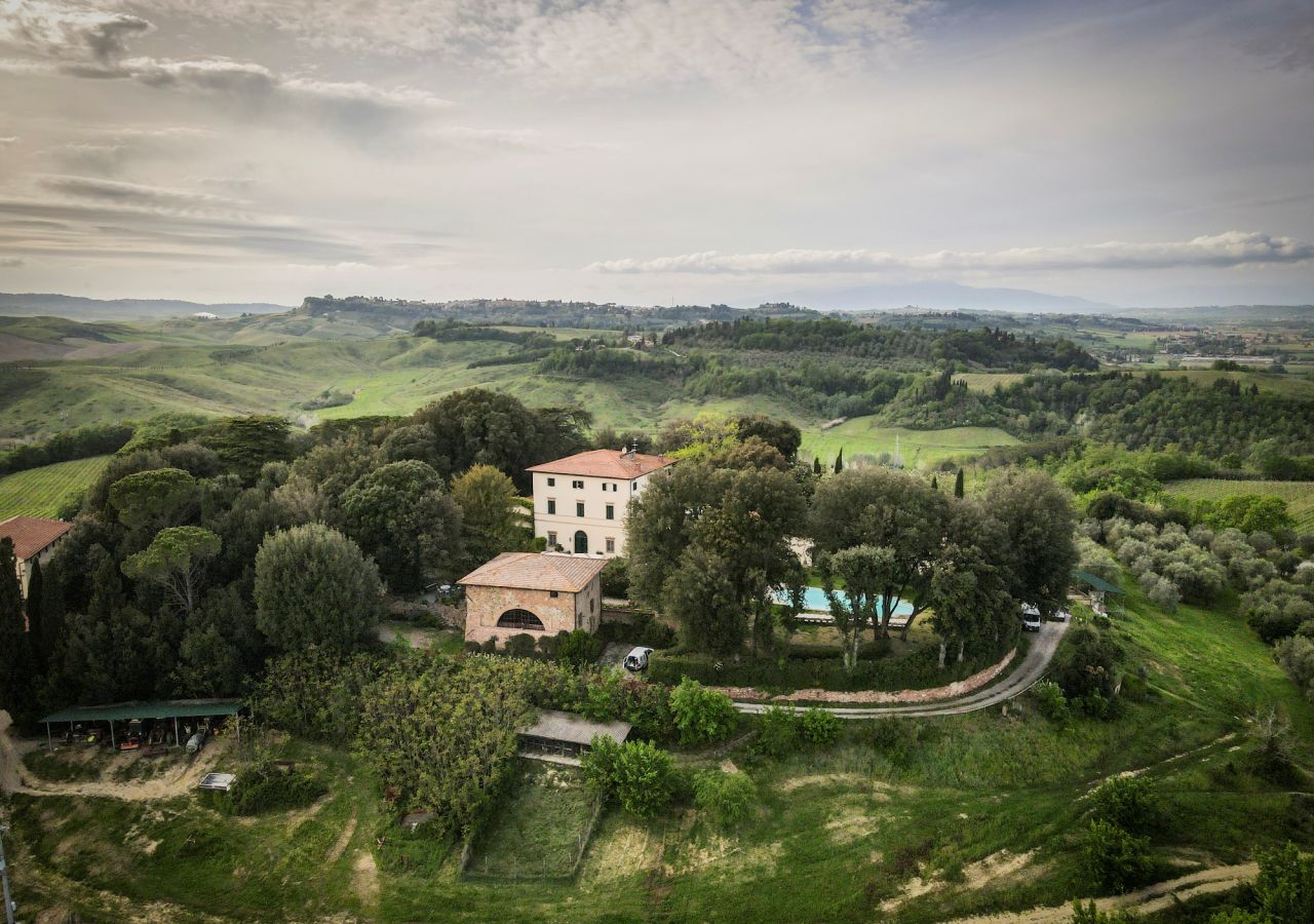 Veduta aerea di Pieve de’ Pitti, con la villa storica e gli edifici rurali immersi nel verde, circondati dalle colline, dai vigneti e dagli oliveti di Terricciola.